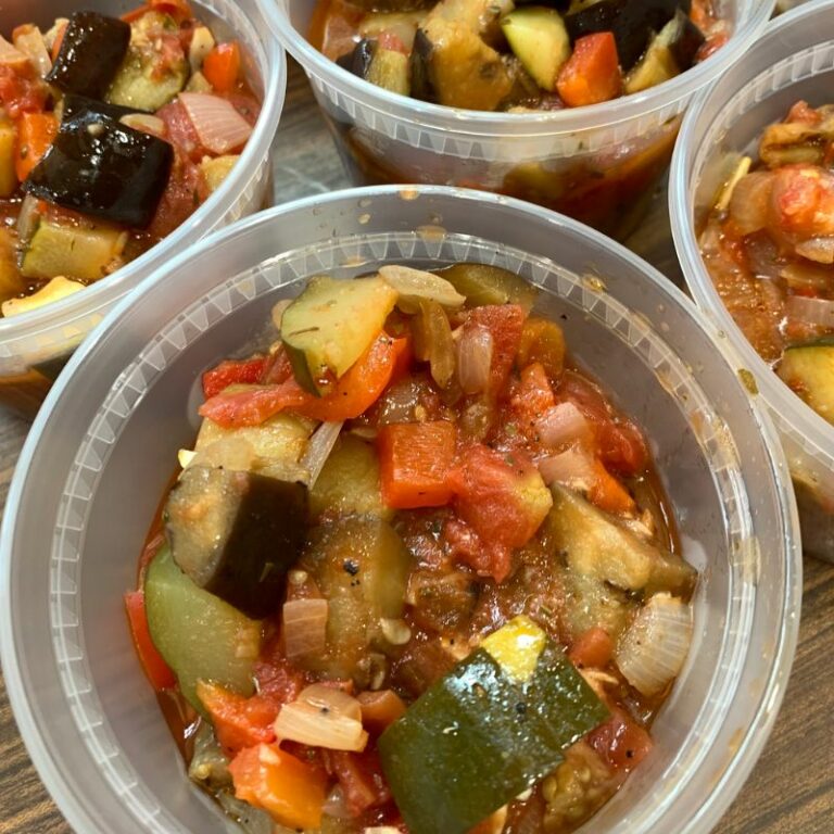 Overhead view of plastic containers filled with veggie stew