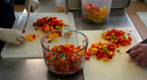 Tri-color peppers being chopped and put in measuring jars