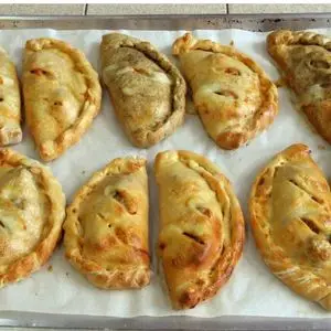 a baking tray with small calzones cooling